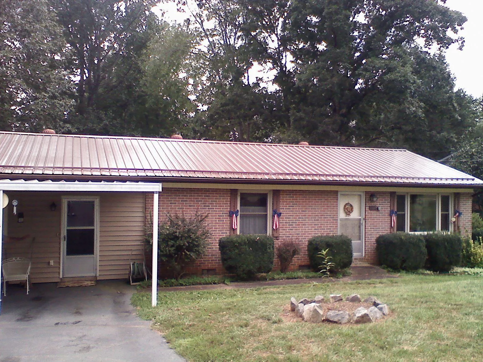 Bronze metal roof and carport on a brick ranch home — Roof Repair work by our crew in Cleveland